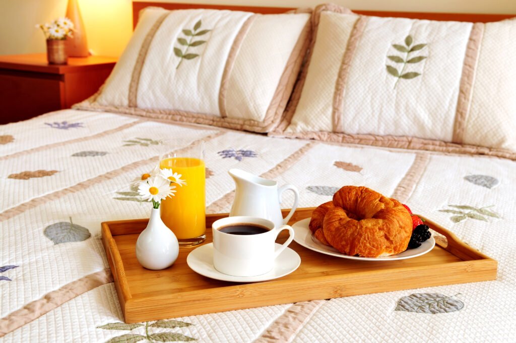 Tray with breakfast on a bed in a hotel room, showing the concept of marketing a lodge